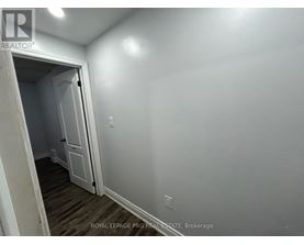 A white door is open to a room with a wooden floor.