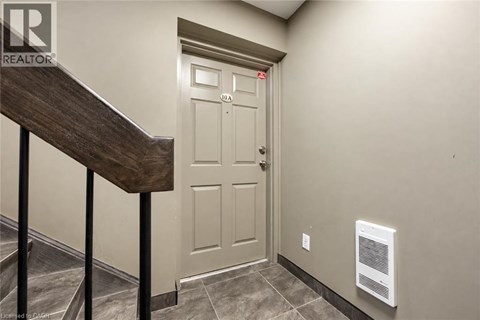 A white door with a red label on it is in a hallway.