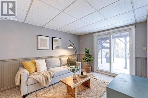 A living room with a grey couch, a wooden coffee table, and a large window.
