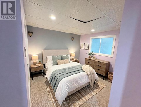 A bedroom with a bed, nightstand, and lamp.