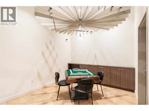 A room with a pool table and chairs.