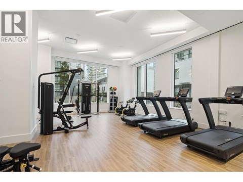 A gym with treadmills, weights, and exercise equipment.