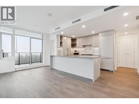 A modern kitchen with white cabinets and a large island.