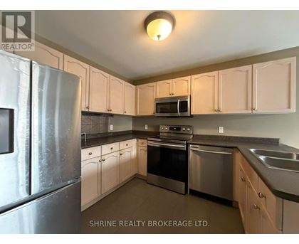 A kitchen with white cabinets and stainless steel appliances.