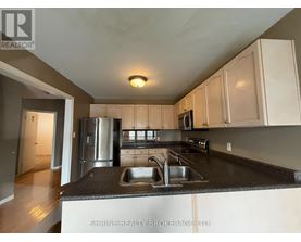 A kitchen with a sink and a refrigerator.