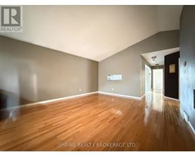 A room with wooden flooring and a white ceiling.