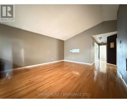 A room with wooden flooring and a white ceiling.