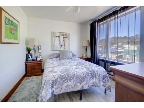 A bedroom with a large bed and a painting on the wall.