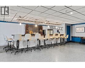 A conference room with white chairs and a grey floor.