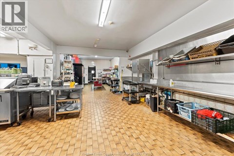 A large commercial kitchen with wooden floors and stainless steel appliances.
