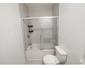 A white toilet sits next to a glass shower stall.