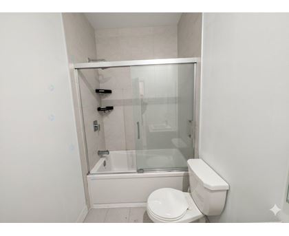 A white toilet sits next to a glass shower stall.