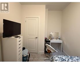 A bedroom with a bed, desk, and chair.