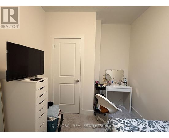 A bedroom with a bed, desk, and chair.