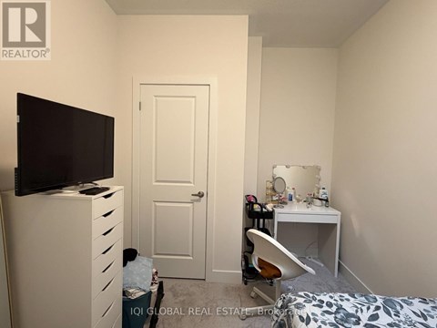 A bedroom with a bed, desk, and chair.