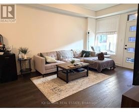 A living room with a couch, a coffee table, and a bed.