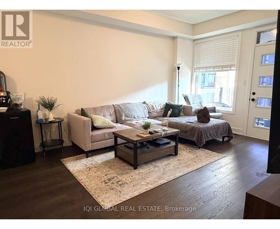 A living room with a couch, a coffee table, and a bed.