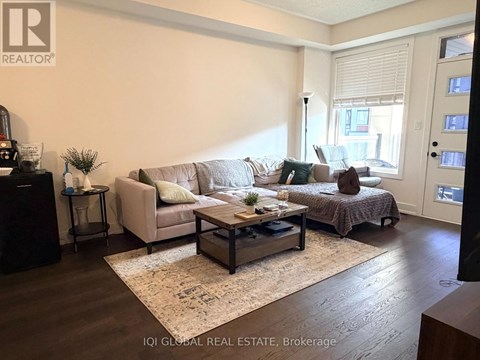 A living room with a couch, a coffee table, and a bed.