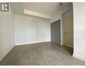 A room with a grey floor and a white wall with a door on the right side.
