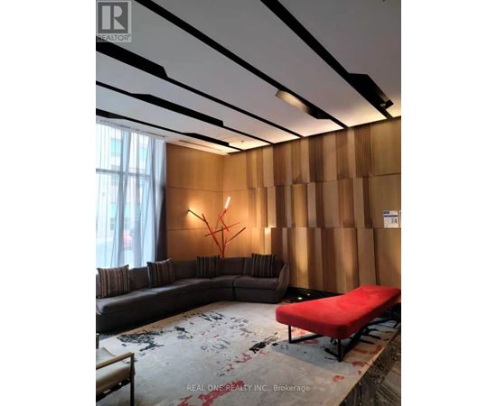 A living room with a grey sofa and a red bench.