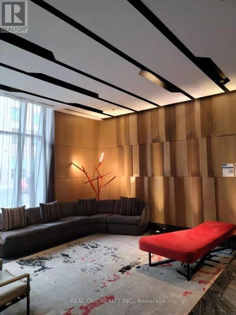 A living room with a grey sofa and a red bench.