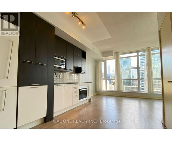A modern kitchen with black cabinets and white appliances.