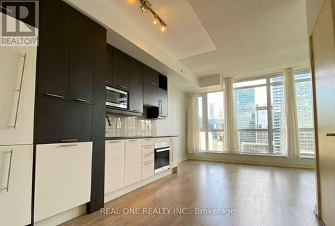 A modern kitchen with black cabinets and white appliances.