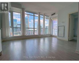 A spacious room with large windows overlooking a cityscape.