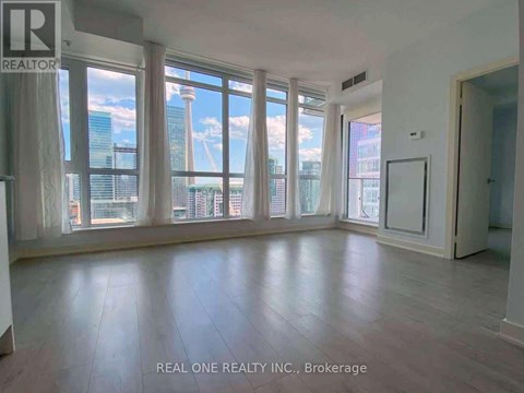 A spacious room with large windows overlooking a cityscape.