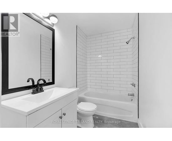 A white bathroom with a sink, toilet and bathtub.