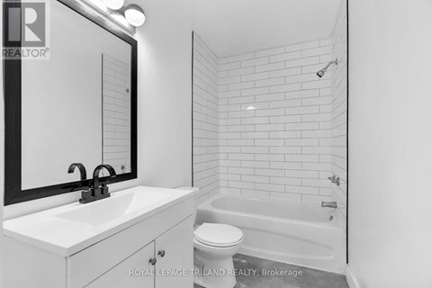A white bathroom with a sink, toilet and bathtub.