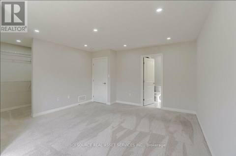 A large, empty room with a carpeted floor and white walls.