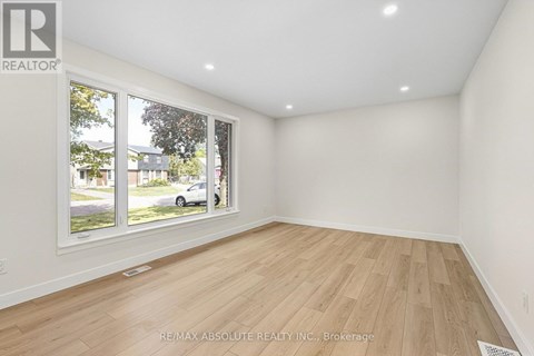 A room with a large window and wooden flooring is on the market with RE/MAX Absolute Realty Inc.
