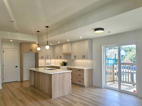 A modern kitchen with wooden cabinets and a white countertop.