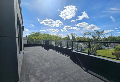 A sunny day with clouds in the sky and a building in the foreground.