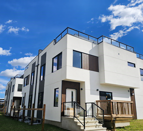 A modern white building with black railings and a balcony.