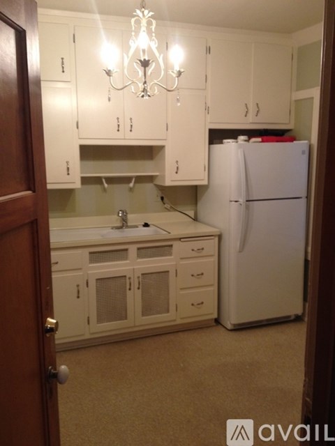 A kitchen with white appliances and cabinets.