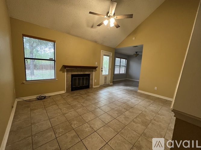 A living room with a fireplace and a ceiling fan.