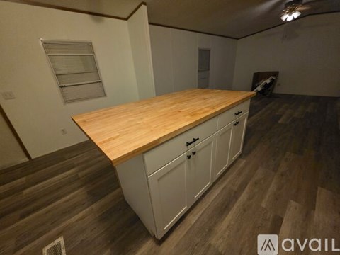 A kitchen with a wooden countertop and white cabinets.