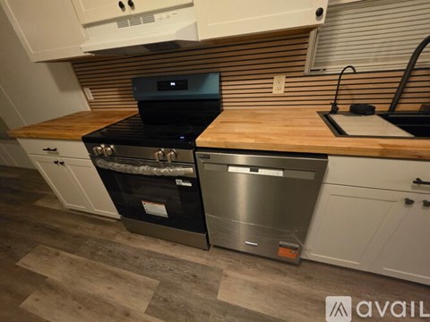A modern kitchen with a stainless steel dishwasher and a black oven.
