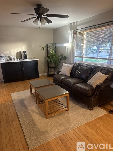 A living room with a brown leather couch and a wooden coffee table.