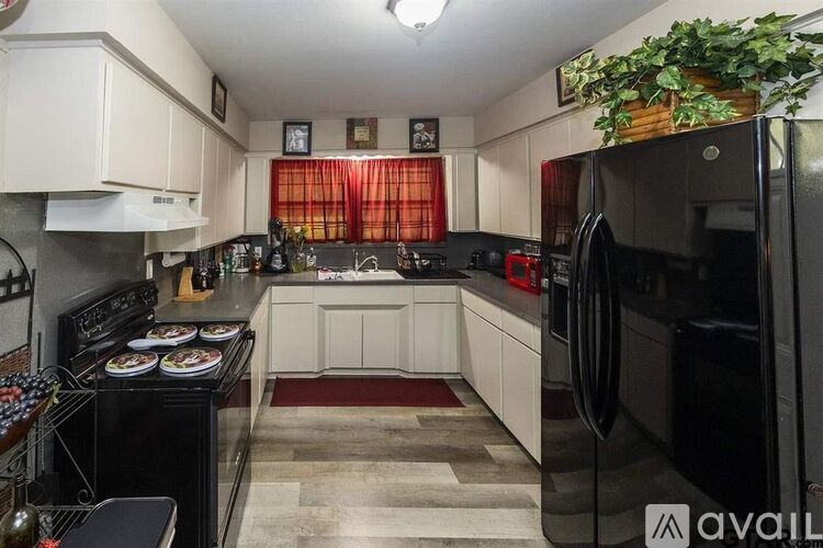 A kitchen with black appliances and white cabinets.