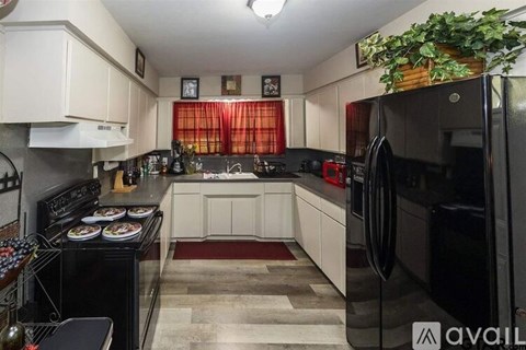 A kitchen with black appliances and white cabinets.