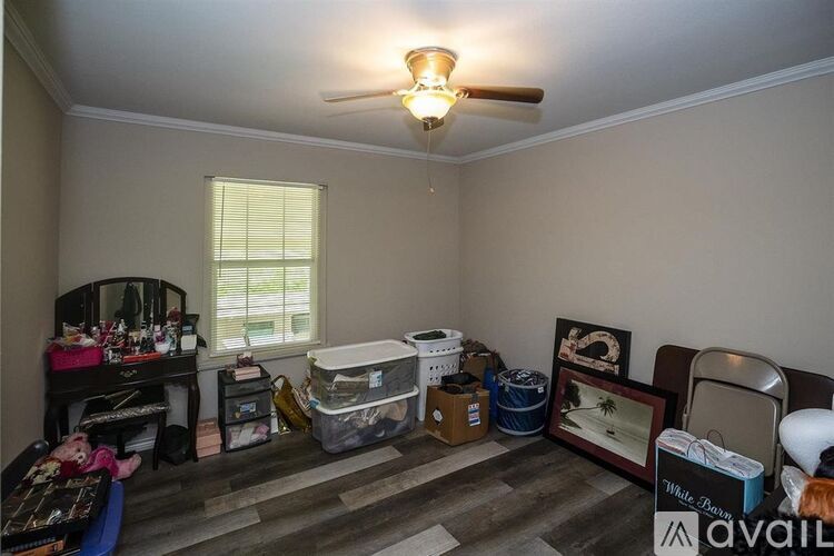 A room with a ceiling fan and a window with blinds.