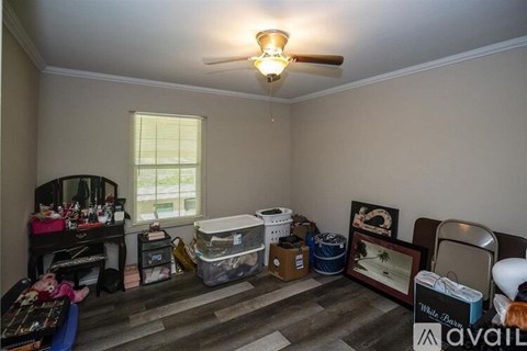A room with a ceiling fan and a window with blinds.