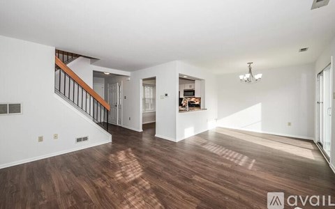A spacious living room with hardwood floors and a staircase leading to the upper level.