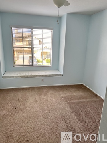 A room with a window and a fan.