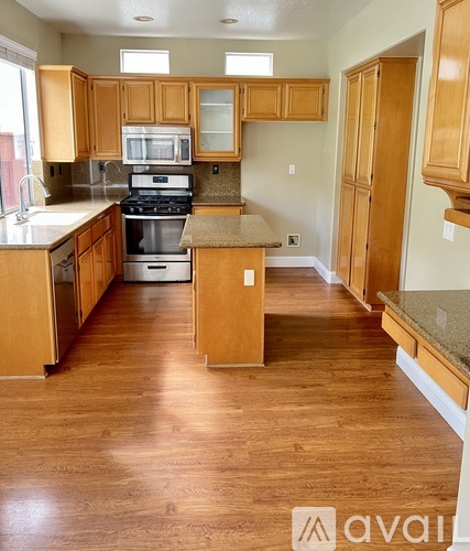 A kitchen with wooden cabinets and a stove top oven.