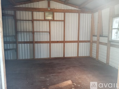 A room with wooden beams and a corrugated metal wall.