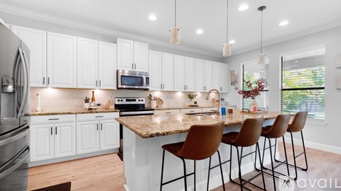 A kitchen with white cabinets and a granite countertop.